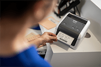 Nurse printing patient label using Brother TD-4410D desktop label printer