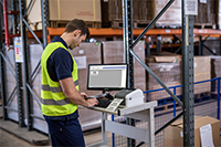 Man wearing hi-vis printing in warehouse using Brother TD-4420DN desktop label printer