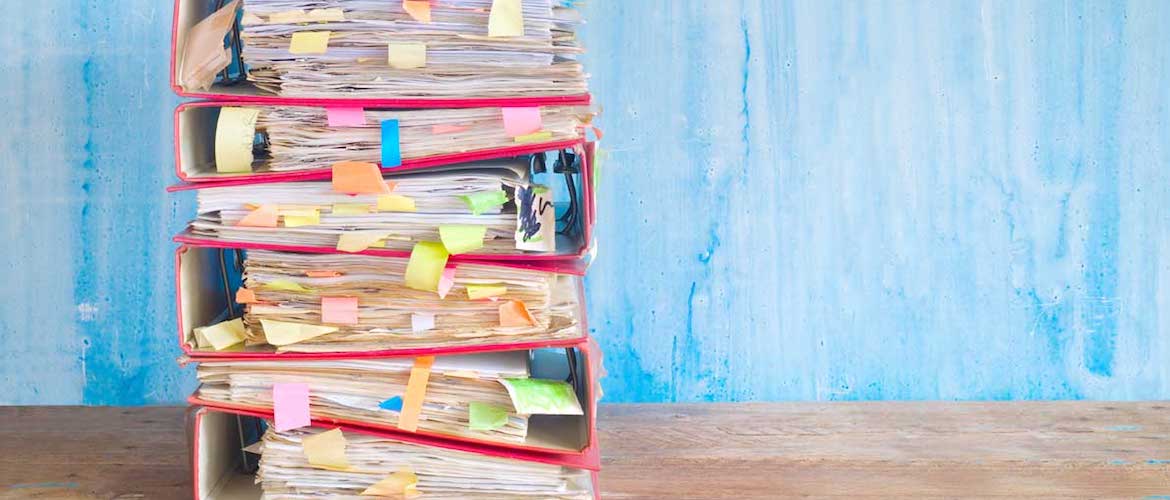 a pile of files stacked high, full of paper
