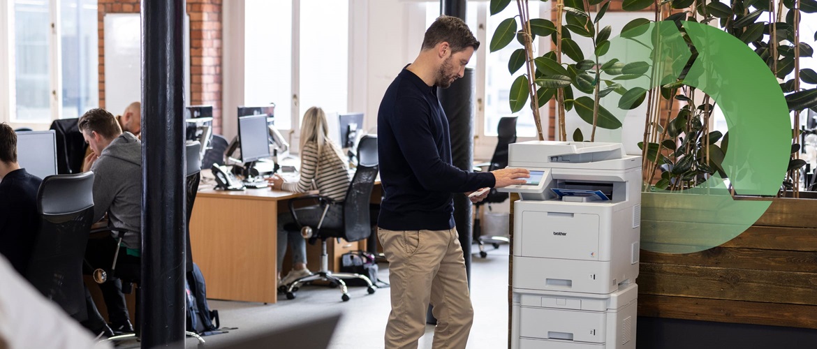A man using a laser printer in an busy SMB environment with a circular process graphic in the background