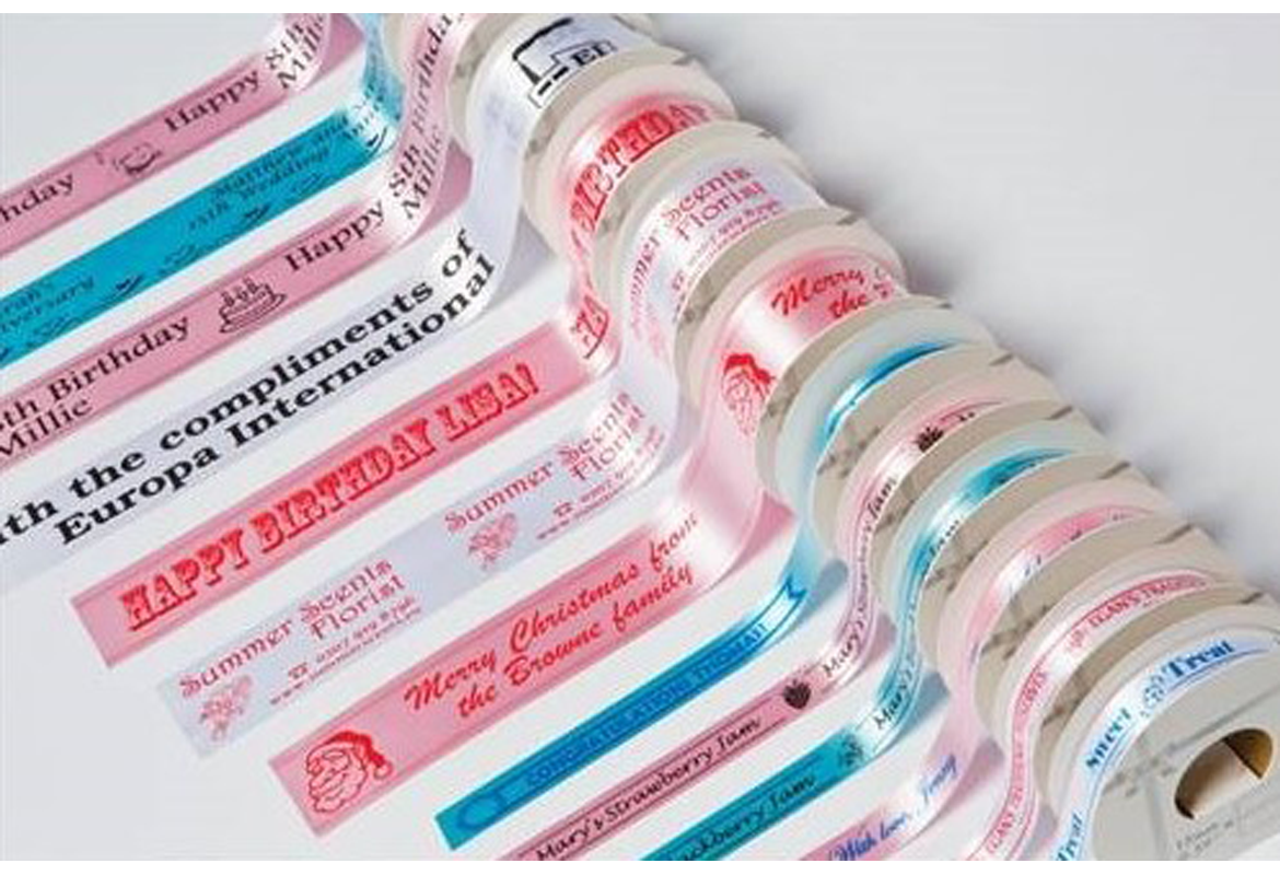 A row of assorted rolls of coloured ribbon displaying various printed messages