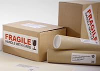 Address and fragile labels adhered to brown cardboard packaging